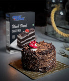 Chocolate cake with a box of Crust N Crumbs Black Forest Cake Mix on a table.