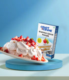 A package of Crust N Crumb Whipping Cream Powder next to a plate with whipped cream topping and strawberries on it.